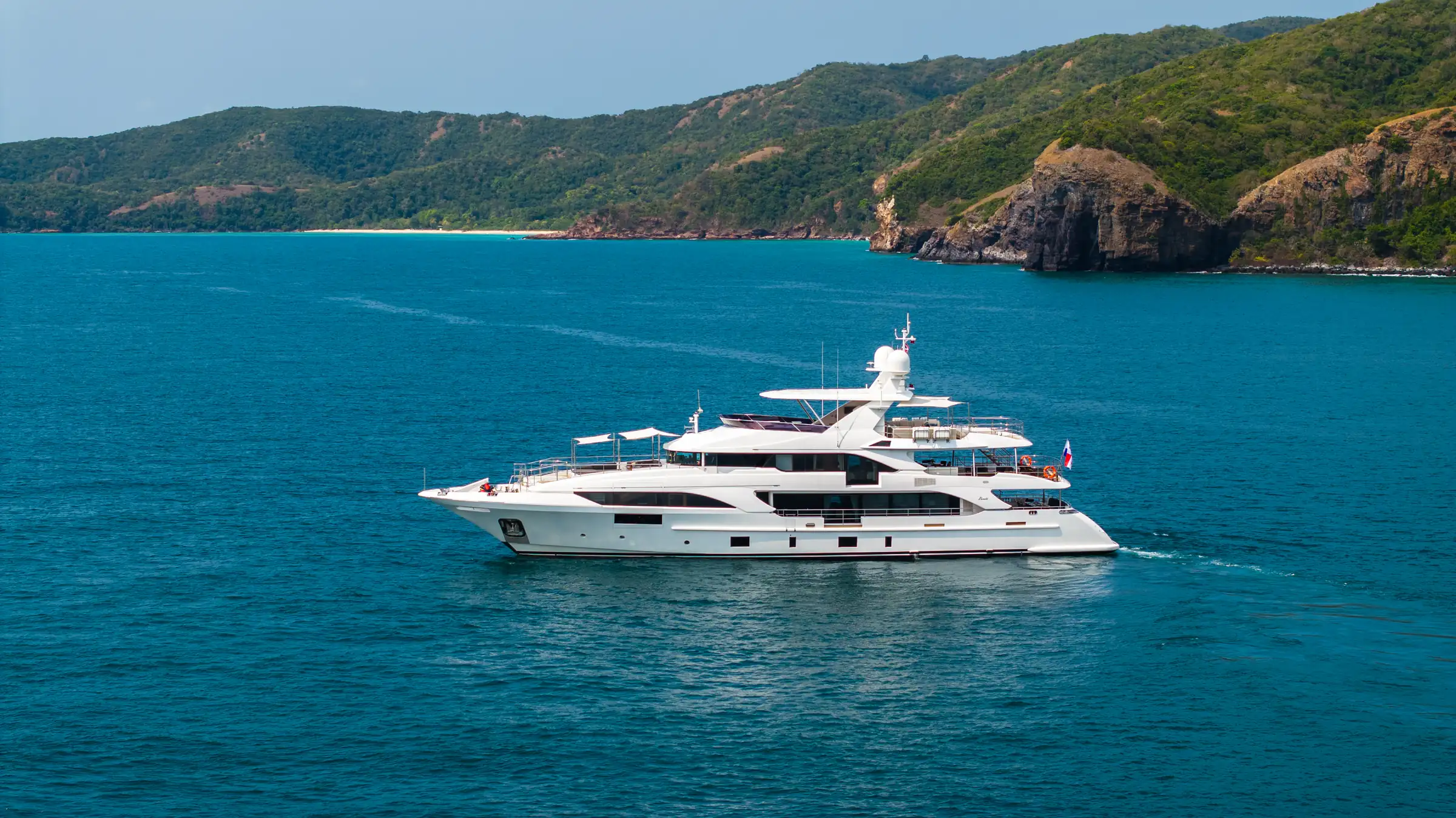 Asia Poseidon at anchor off a white sand beach