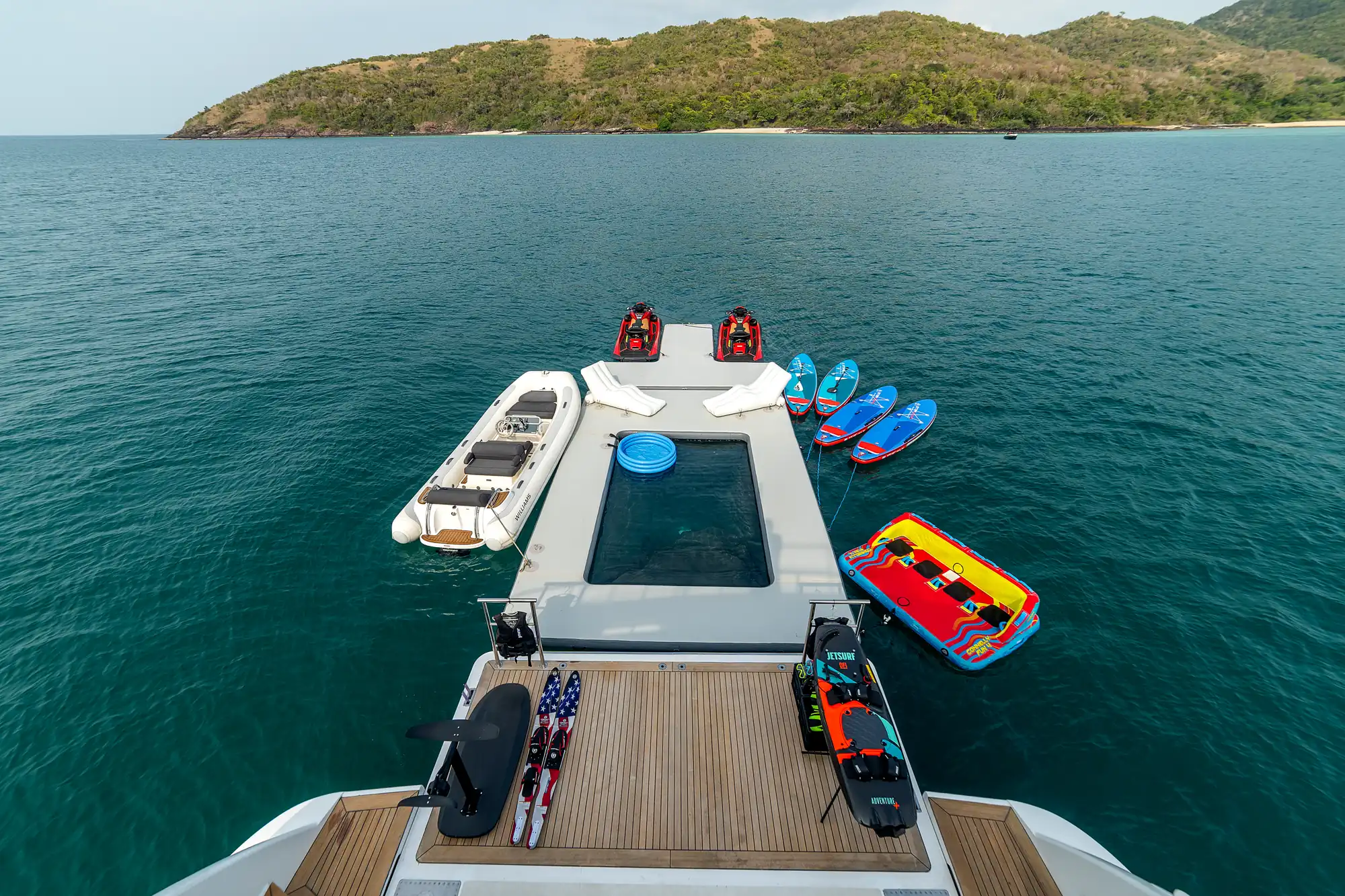 The swim platform with the sea pool, jet skis and paddleboards alongside